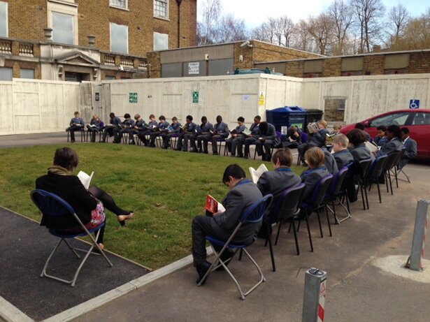 Picture of students assembled outside and reading quietly