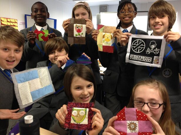 Picture of students displaying the quilts they've made